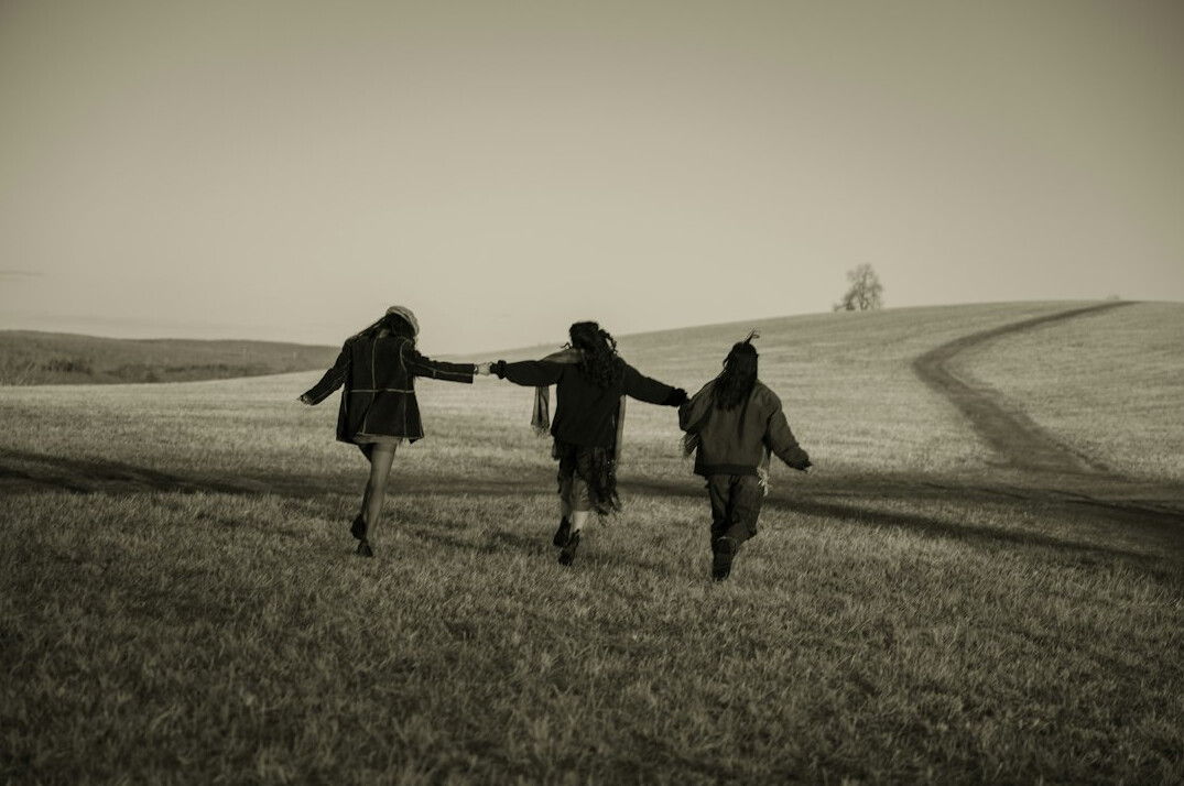Friends joining hands together outdoors